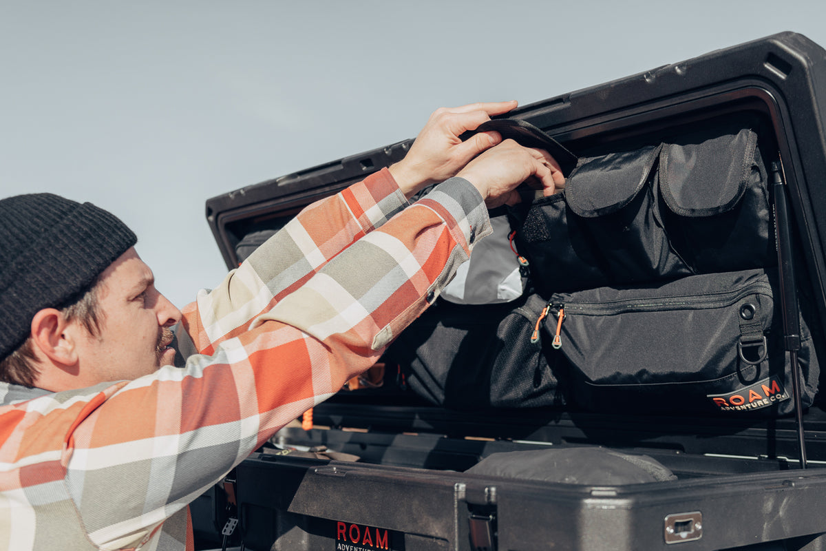 Man arranging gear and tools using the lid organizer in an 83L Rugged Case enlarged image 3